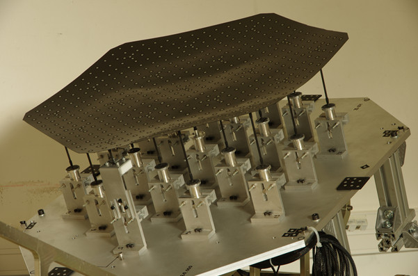A matrix of linear actuators makes it possible to modify the reflective surface of this reconfigurable antenna using remote commands. Image credit: TAS-F